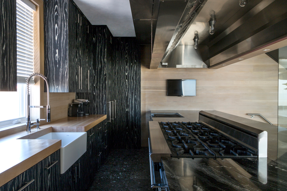 The galley-style kitchen features a large indoor grill, 10-burner stove, ovens, refrigerator drawers, warming drawers, beverage drawers and lots of workspace, all with a commercial grade exhaust hood above.